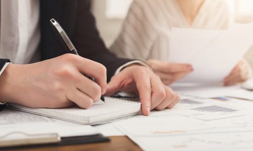 closeup-business-partners-hands-writing-notes-checking-documents-financial-background-count-pay-account-copy-space-selective-focus